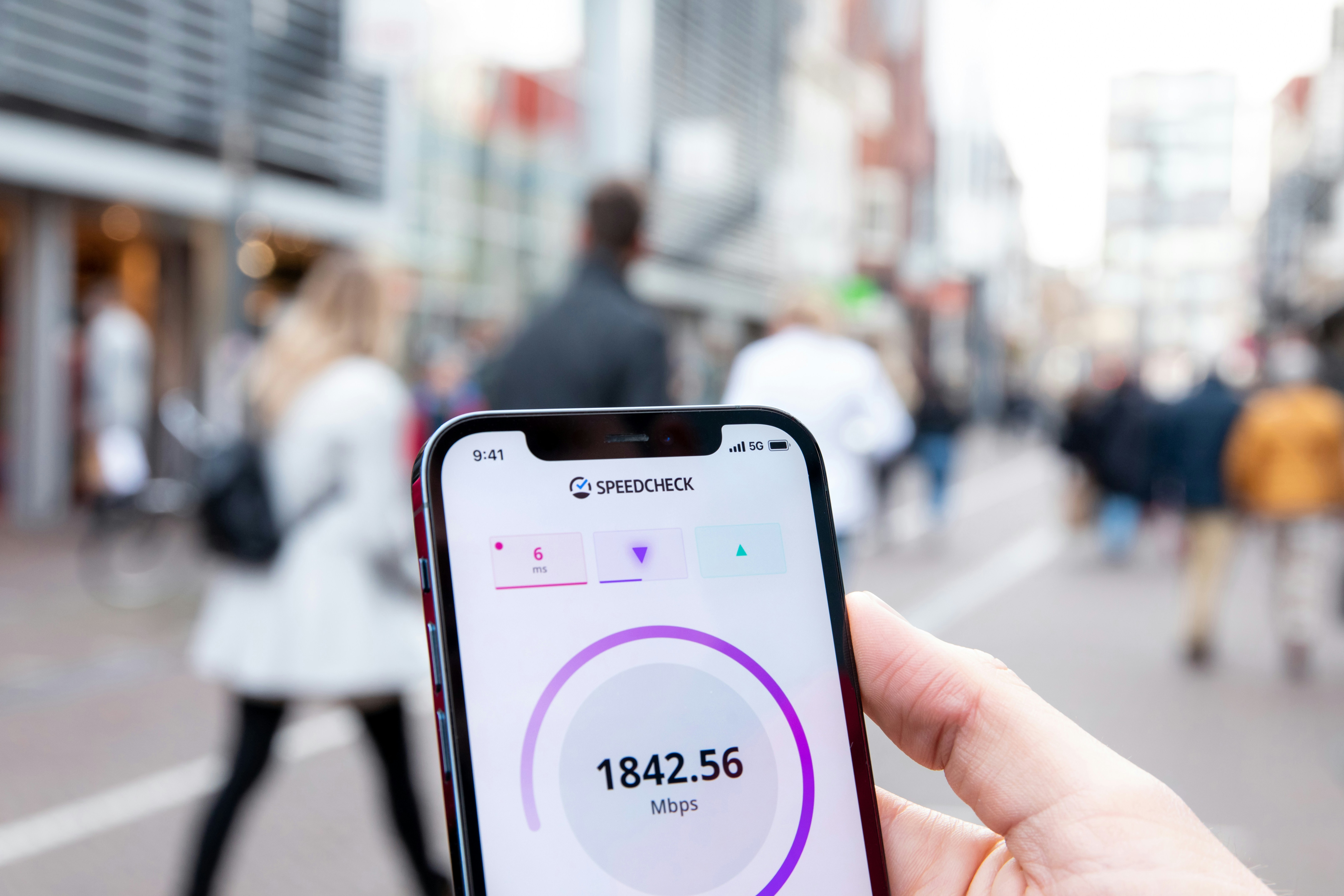 A Phone showing  a speedcheck of the 5g network. reading out: 1842 mpbs and 6ms latency